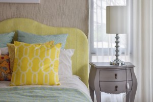Yellow and green and pattern pillows on classic style bed and re